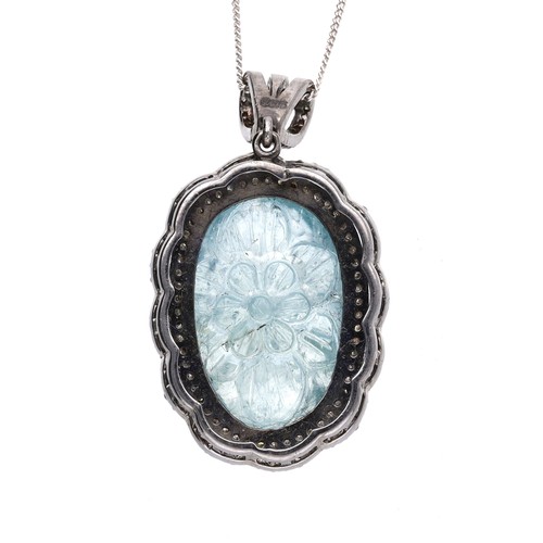51 - Attractive silver pendant on a slender chain, set with an oval carved aquamarine in a diamond border... 
