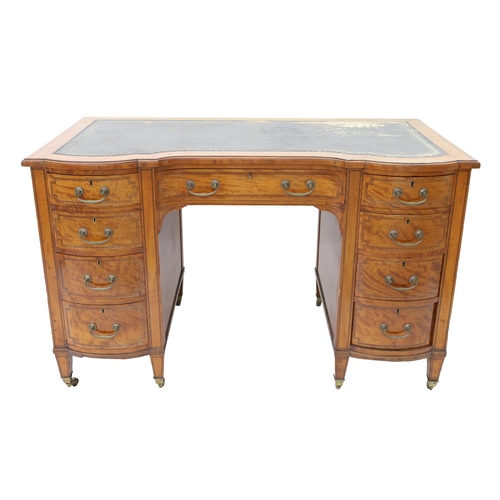 Attractive late Victorian satinwood kneehole desk, with leather inset top, the central frieze door with four short drawers to each side, tulip wood cross banding on square tapered legs with brass capping and castors, 48" wide, 25.5"deep, 30" high