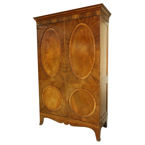 Early 19th century mahogany "Channel Islands Wardrobe", the inlaid cornice with satinwood banding above a pair of oval recess panel doors, with further satinwood banding to the base, with undulating apron and shaped bracket feet, 53" wide, 20" deep, 86" high