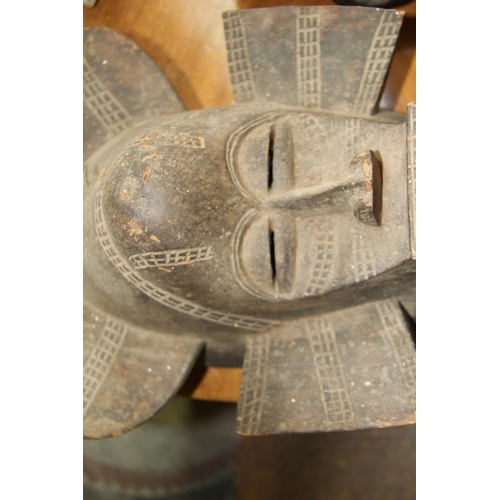 2002 - African: a tribal carved wood mask, of stylised form; together with a wooden club. (2)