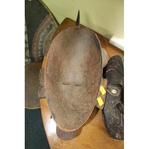 2002 - African: a tribal carved wood mask, of stylised form; together with a wooden club. (2)