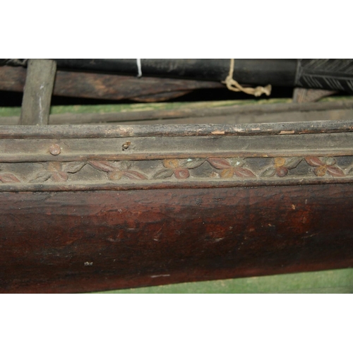 2058 - A ceremonial dug out canoe, with carved freize, 197cm long.