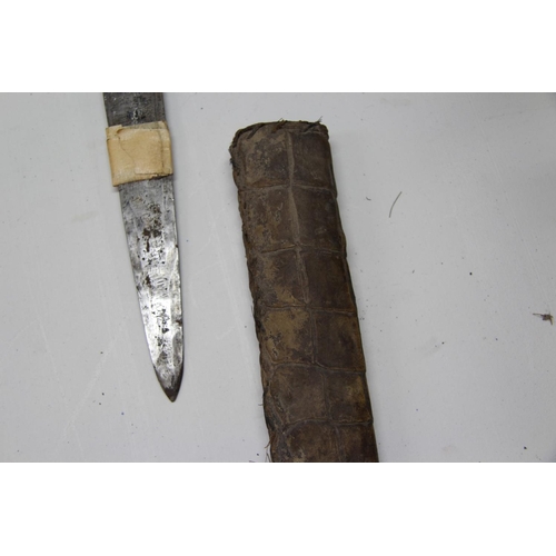 2085 - African: a knife having carved wood handle and snakeskin scabbard, approx 48cm long.