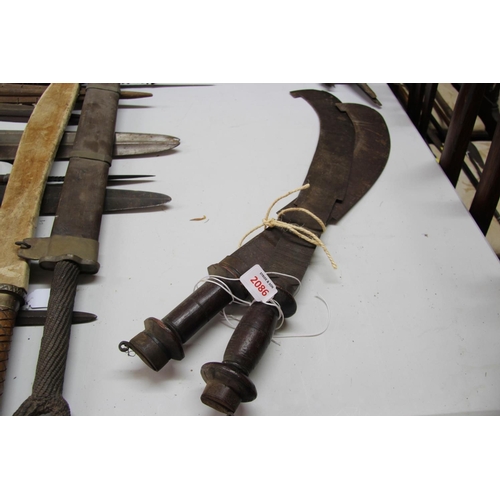 2086 - African: a pair of swords having carved wooden handles and curved blades, approx 71cm long.