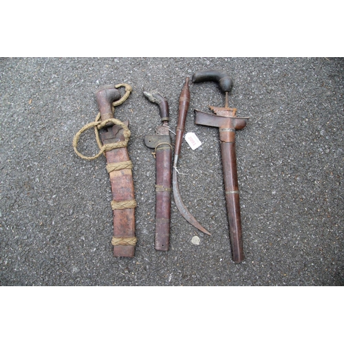 2091 - Four Indonesian weapons, comprising: a kris with horn handle; two knives in wooden scabbards; and a ... 