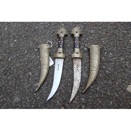 2093 - Two kukris; together with two small jambiya; and a small Norwegian hunting knife. (5)