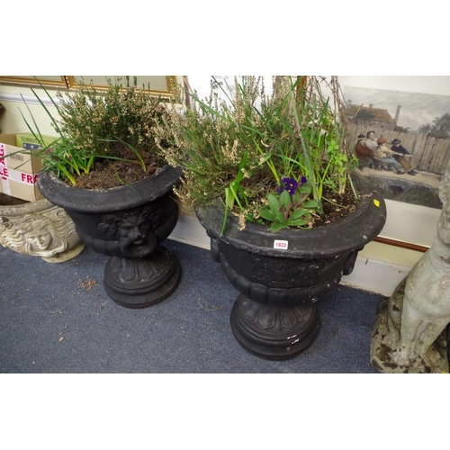 1822 - A pair of black painted composition stone twin handled urns, 66cm high.