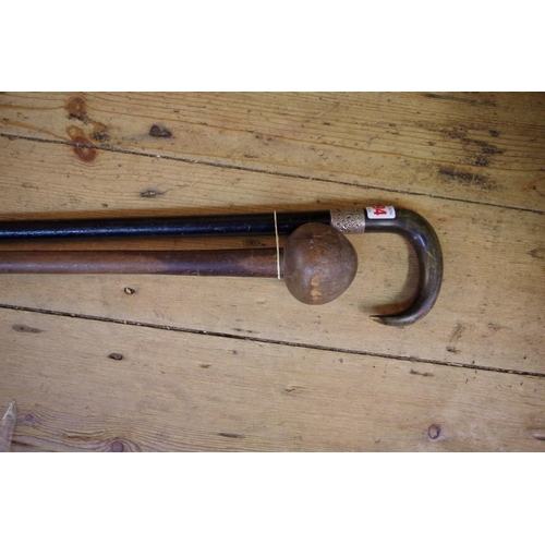 1894 - A horn handled, silver and mounted and ebonized walking stick; together with another knobkerrie styl... 