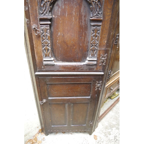 1261 - A 17th century style carved oak panelled standing corner cupboard, 172.5cm high.... 