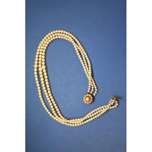 148 - A three strand graduated pearl necklace, having 9ct gold and pearl cluster clasp.