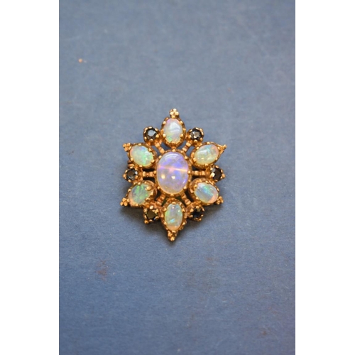 91 - A 9ct gold star pendant/brooch, set seven opals and six sapphires, 3cm.