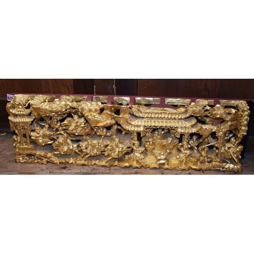 675 - A Chinese pierced and carved giltwood panel, decorated with warriors, 20 x 73.5cm.