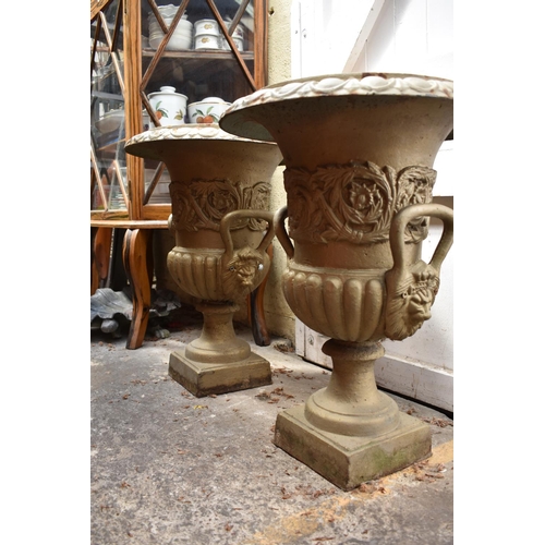 1280 - A pair of painted cast iron twin handled garden urns, 62cm high.