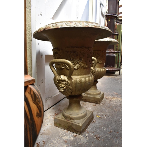 1280 - A pair of painted cast iron twin handled garden urns, 62cm high.