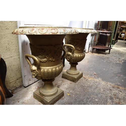 1280 - A pair of painted cast iron twin handled garden urns, 62cm high.