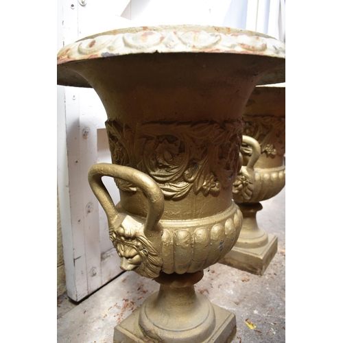 1280 - A pair of painted cast iron twin handled garden urns, 62cm high.