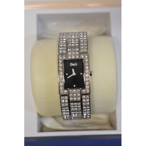 141 - A boxed ladies Guess wristwatch; together with a boxed Dolce et Gabbana ladies wristwatch; and a box... 