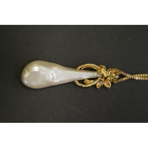 148 - A floral emerald and diamond set baroque pearl pendant on 18ct gold box chain.