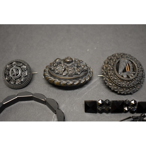 181 - Three Victorian carved jet brooches; together with a similar bracelet; and other examples.... 