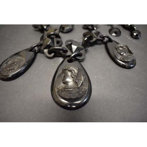 182 - A large Victorian jet necklace, have three carved cameo pendants, (a/f).