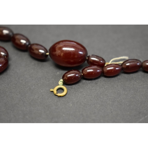 184 - A string of graduated cherry amber style beads, 57cm, 35.5g