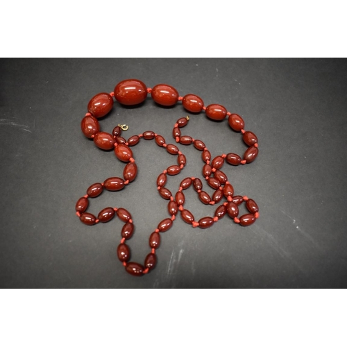 191 - A string of graduated cherry red amber style beads, 113cm, 93.5g