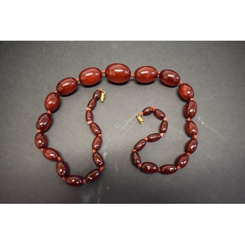 192 - A knotted string of graduated cherry red amber style beads, 57cm, 48g.