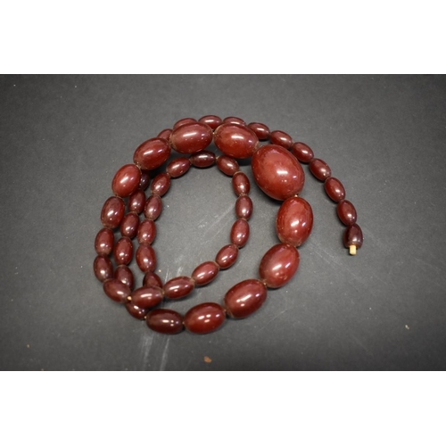 198 - A string of graduated cherry amber style beads, 82cm, 91.8g.