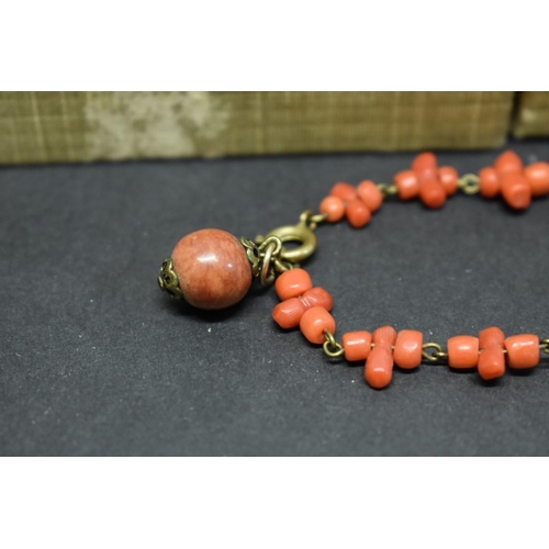 201 - An antique carved coral chain having reclining cherub clasp; together with two other items of carved... 