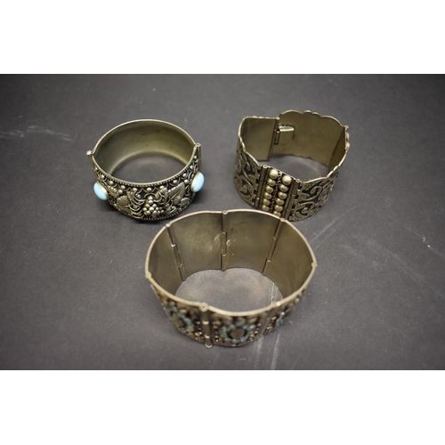 205 - Three large white metal cuff bracelets.