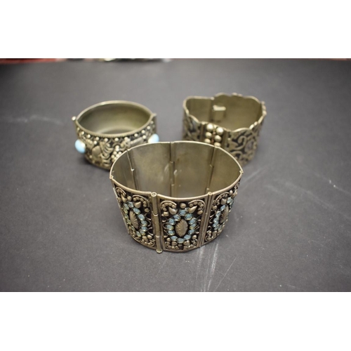 205 - Three large white metal cuff bracelets.