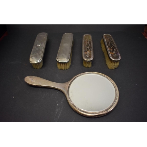 94 - Three silver and tortoiseshell dressing table items; together with two silver backed brushes, (5).... 