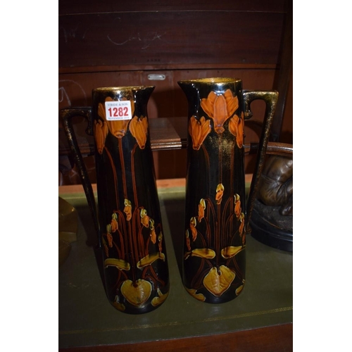 1282 - A pair of Art Nouveau pottery ewers, 34cm high.