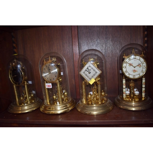 1302 - Four various anniversary clocks, each with glass dome. 