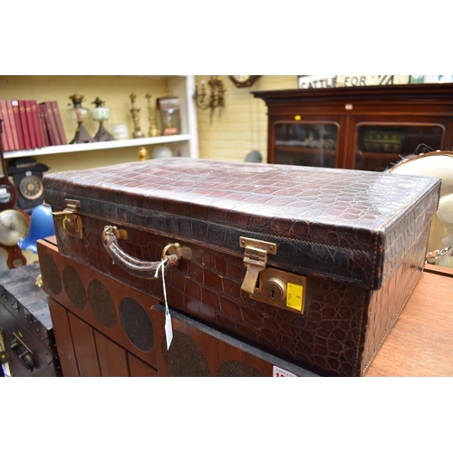 1332 - A vintage crocodile suitcase, inscribed 'Finnigans...', 62.5cm wide.