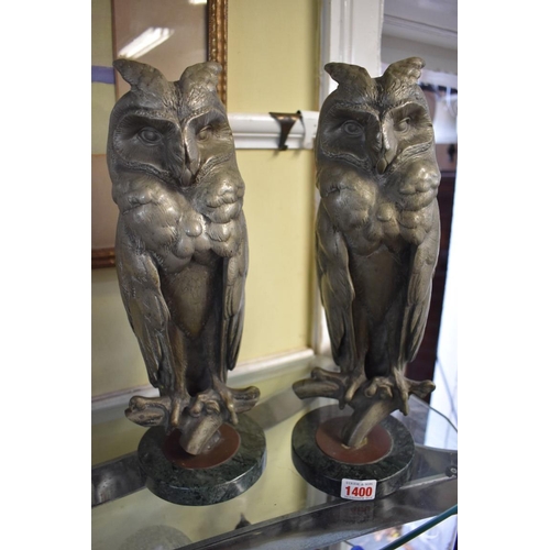 1400 - A pair of cast metal models of long-eared owls, each on a green marble base, total height 37cm.... 