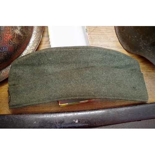 1697 - A German World War II green felt side cap, with cloth SS badge. 