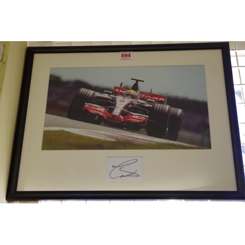 594 - Photographs: a colour image of Lewis Hamilton in McLaren, signed to reserved margin in mount, 21 x 3... 