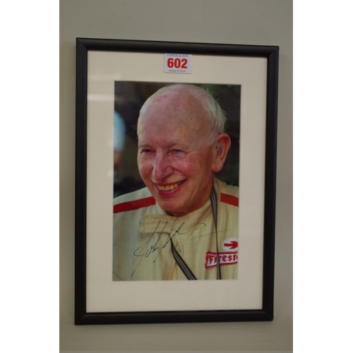 602 - Photographs: a colour image of John Surtees, signed, image 22 x 14.5cm. 