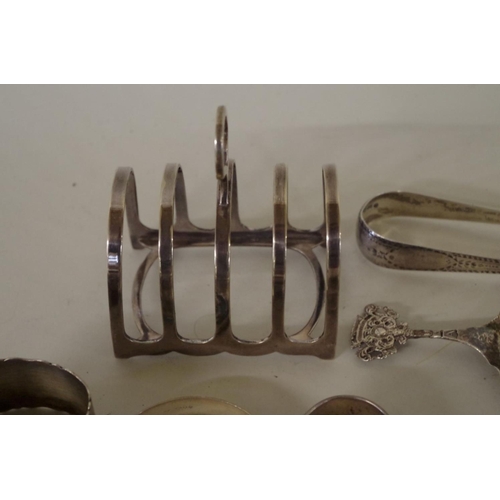 70 - A mixed group of silver, to include: a pair of silver Georgian sugar tongs; two silver bangles; and ... 