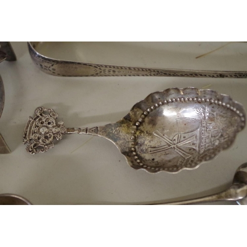 70 - A mixed group of silver, to include: a pair of silver Georgian sugar tongs; two silver bangles; and ... 