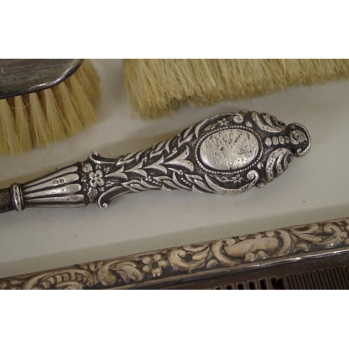 77 - Four various silver brushes; together with two silver comb slides; and a silver handled button hook.... 