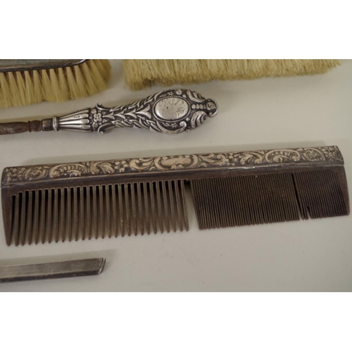 77 - Four various silver brushes; together with two silver comb slides; and a silver handled button hook.... 