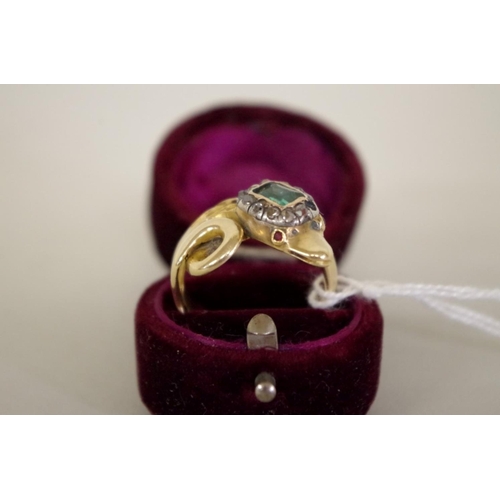 98 - An unmarked yellow metal coiled snake ring, the head set Georgian emerald and diamonds, with ruby ey... 