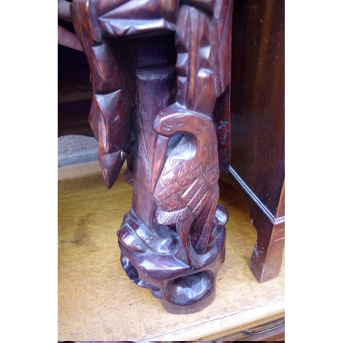 1175 - An Oriental carved hardwood figural lamp, 60cm high. 