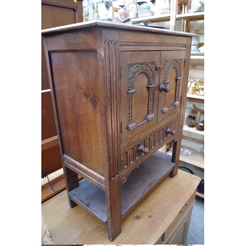 1194 - A reproduction carved oak small cupboard, 69cm wide. 