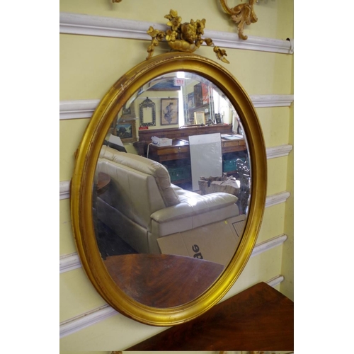 1711 - A gilt framed oval wall mirror, 92cm high x 70cm wide. 