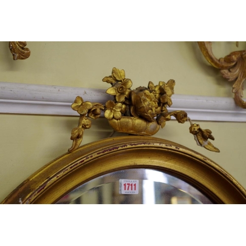 1711 - A gilt framed oval wall mirror, 92cm high x 70cm wide. 