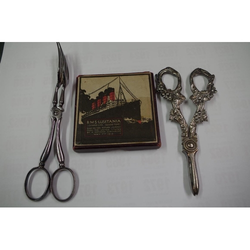 90 - A boxed Lusitania medal; together with a pair of plated grape scissors; and a pair of plated serving... 