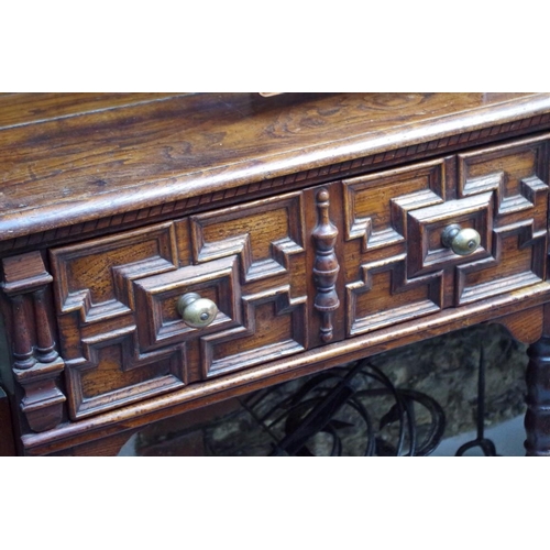 1119 - An 18th century oak dresser base, with geometrically moulded frieze drawers above reel turned legs j... 